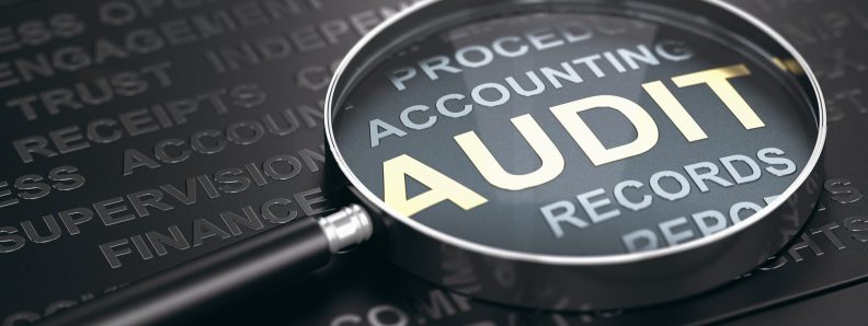 Magnifying glass with focus on the word audit written in golden letters and other accounting words over black background. 3D illustration.